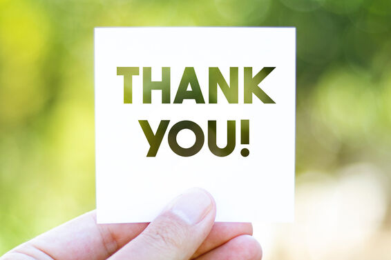 fingers holding a paper with Thank You message